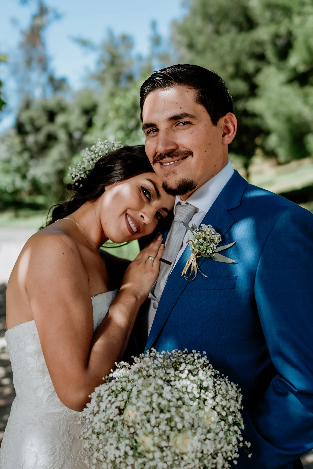 A smiling couple leaning in close on their wedding day